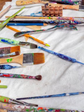 Sanatçı fırçaları. Beyaz fabr üzerinde birçok sanatçı araçları Düz yatıyordu