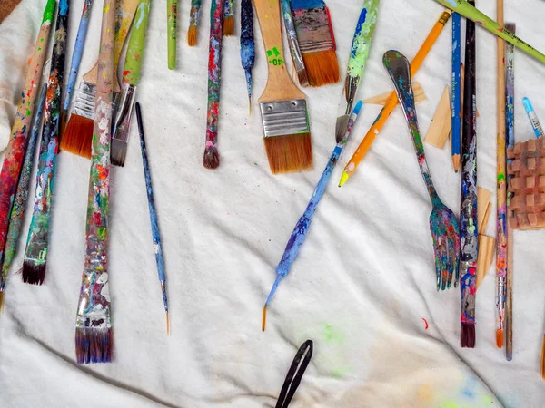 Pincéis de artista. leigos planos de muitas ferramentas de artista em fabr branco — Fotografia de Stock