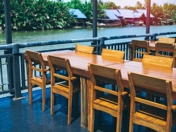 Wooden dining table set near the river.