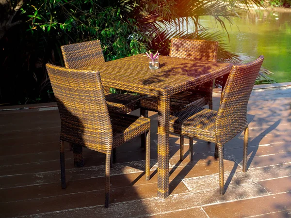 Set di mobili da tavolo in rattan su terrazza in legno . — Foto Stock