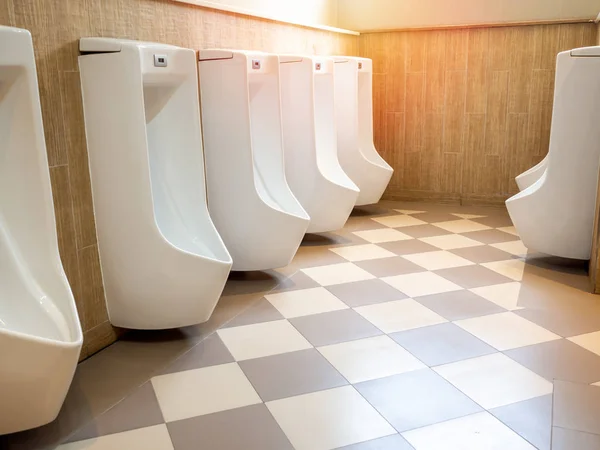 Row of modern luxury white automatic urinal for men on square ti — Stock Photo, Image