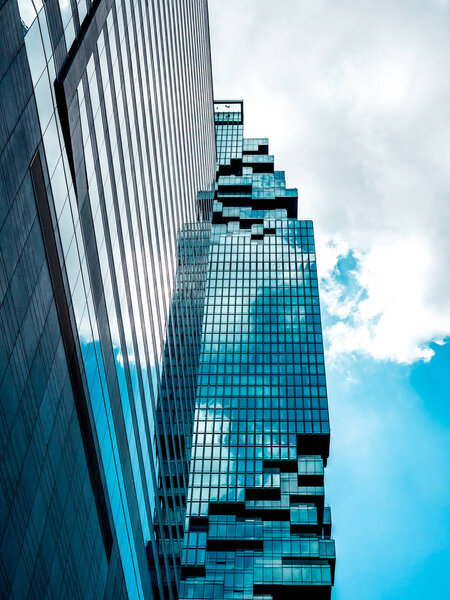 Bangkok, Thailand - June 22, 2019. Bottom view of Mahanakhon building on blue sky and cloud background on sunshine day, Mahanakhon building that in the central business district of Bangkok, Thailand. Vertical style.
