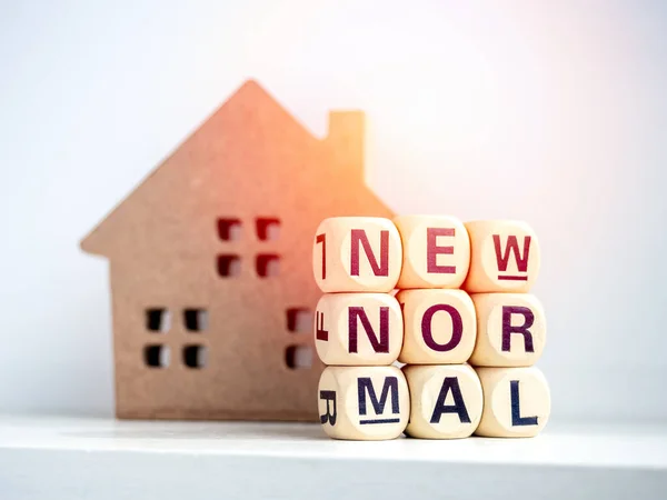 New Normal and stay safe stay home concept, Wooden house and words on wooden alphabet cube on white background.