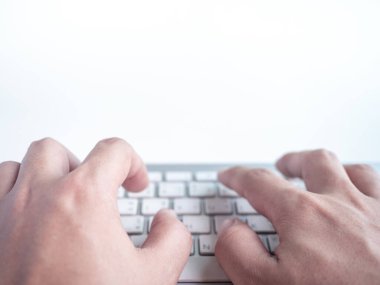 Uzaktan kumandalı kablosuz bilgisayar klavyesine yakın çekim elleri kopyalama alanı olan beyaz bir arkaplanda izole edildi.