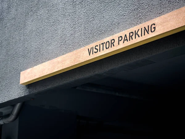 Visitor parking sign. Parking wooden sign above the parking space in modern apartment with copy space.