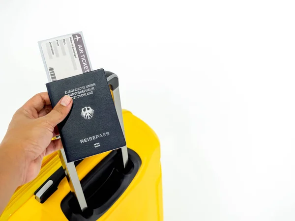 コピースペース付きの白い背景に黄色のスーツケース付きの手押しパスポートと航空券の搭乗券 ドイツの青いパスポートと黄色の荷物 旅行のコンセプト — ストック写真