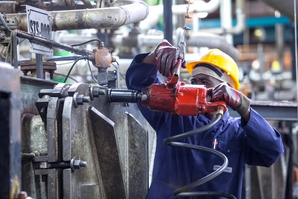 Johannesburg, South Africa - 17 November, 2015, 2018: Man tightening nuts in manufacturing plant.