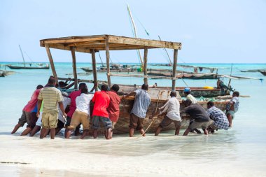 Stone Town, Zanzibar, 24 Mayıs - 2015: balıkçı teknesi denizin iterek erkekler.