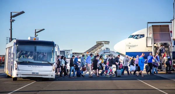 Passengers at airport getting out bus and into aircraft — Stock Photo, Image