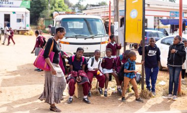 Mbabane, Svaziland, 26 Mayıs 2019: Yol kenarında çocukların yanından geçen bir kadın