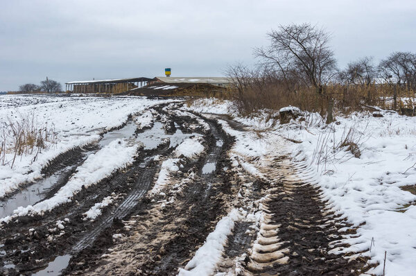 Ukrainian landscape with dirty country to farm at gloomy winter day