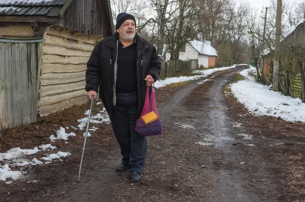 Pozitif yaşlı köylü kırsal köy Pidstavky, Sumskaya oblast, Ukrayna boş bir sokakta yürüme