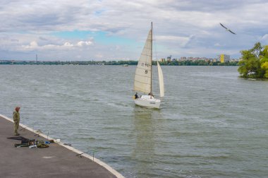 Dnepr, Ukrayna - 24 Eylül, 2016:Scenery yalnız balıkçı, Yelkenli ile Dnepr nehir setin Dnepr merkezi City sonbahar hafta sonu üzerinde uçan martı