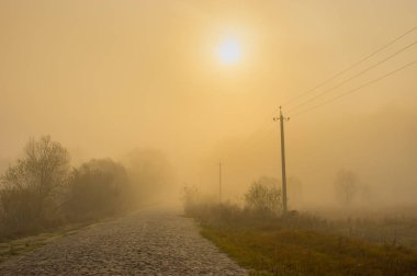 Korkunç manzara ile bir antik taş yol Ukrayna kırsal alanda gün batımında siste