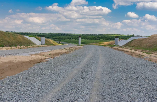 Summer landscape in Ukraine with stone layer of unfinished highway near Dnepr city