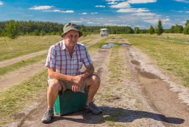 Eski çanta Ukrayna bir ülkede yol üzerinde oturan olgun adam