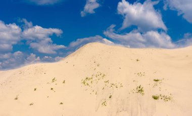 Kumlu tepe ve mavi gökyüzü bulutlu peyzaj