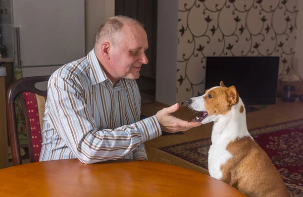Зрелый Мужчина Разговаривает Собакой Сидящей Столом — стоковое фото