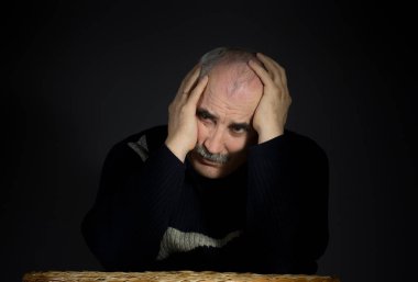 Masada otururken kafasını avuç içi ile olgun adam portresi katlı