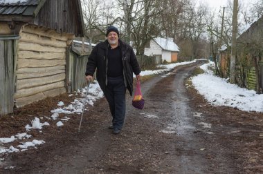 Mutlu ve gülümseyen yaşlı köylü kırsal köy Pidstavky, Sumskaya oblast, Ukrayna boş bir sokakta yürüme