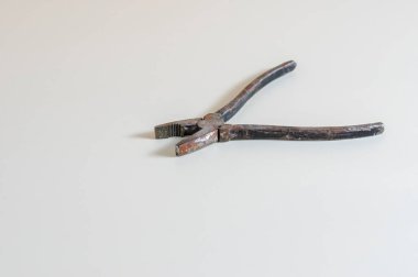 Parlak bir yüzey üzerinde eski paslı pense