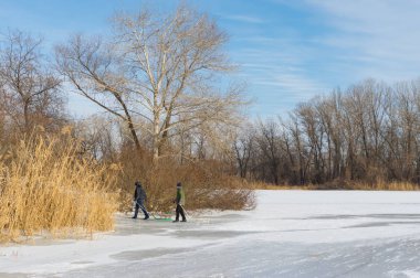 Dnepropetrovsk, Ukrayna - 26 Ocak 2014: Çocuklarda şehir kullanım tepelik banka donmuş nehrin Dnepr için sledging için gitmek.