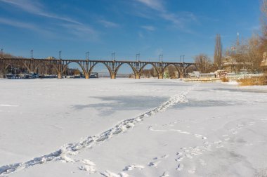 Dnepropetrovsk, Ukrayna - 02 Şubat 2014: Dondurulmuş ve karla kaplı nehir Dnepr Ukraynalı şehrin orta kısmında ayak izleri ile