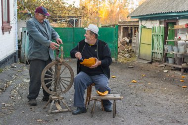 Pidstavky Köyü, Sumskaya oblast, Ukrayna - 15 Ekim 2014: iki yaşlı köylü açık havada çalışırken politik haberleri tartışmak.
