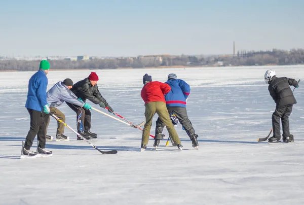 Dnipro, Ukrayna - 22 Ocak 2017: Grup farklı yaş sıradan insanların donmuş nehir Dnipro Ukrayna hokey oynamak
