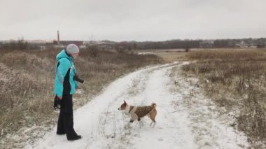 Olgun kadın kış sezonunda açık yürürken alçaklık köpek besleme