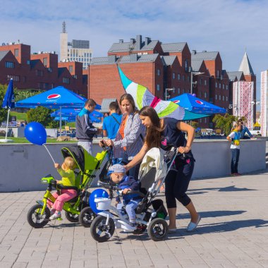 Dnepropetrovsk, Ukrayna - 12 Eylül 2015: Mutlu anne ile bebek arabası central Park'ta şehir gün yerel etkinlik sırasında 12 Eylül 2015, Dnepropetrovsk, Ukrayna yürüme çocuklarda