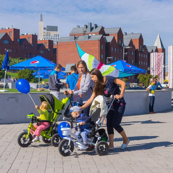Dnepropetrovsk, Ukrayna - 12 Eylül 2015: Mutlu anne ile bebek arabası central Park'ta şehir gün yerel etkinlik sırasında 12 Eylül 2015, Dnepropetrovsk, Ukrayna yürüme çocuklarda