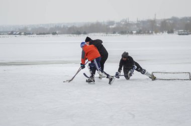 Dnipro, Ukrayna - 28 Ocak 2018: üç sıradan insanların donmuş nehir Dnipro Ukrayna hokey oynamaya