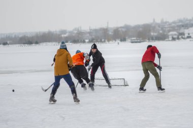 Dnipro, Ukrayna - 28 Ocak 2018: Ukrayna 'da donmuş bir nehirde hokey oynayan bir grup farklı yaşlı insan