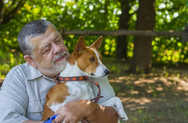 一个长胡子的老人带着他的巴森吉狗的户外肖像 — 图库照片