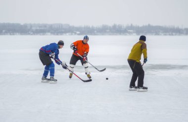 Dnipro, Ukrayna - 28 Ocak 2018: Bir buzlu nehir Dnipro Ukrayna hokey oynamaya farklı insanlar Grup