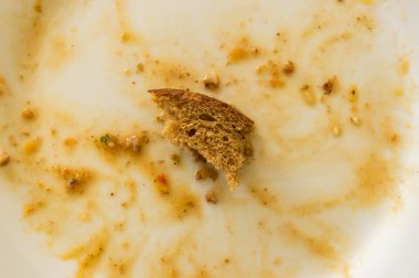 Ekmek buğday kalanlar arasında küçük parça ile beyaz tabakta üstten görünüm