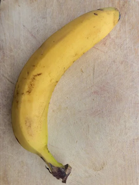 Eenzame Rijpe Banaan Liggend Een Gekraste Houten Oppervlak — Stockfoto