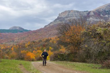 Yalnız uzun yürüyüşe çıkan kimse Crimea'da bir dağ yolda sonbahar sezon