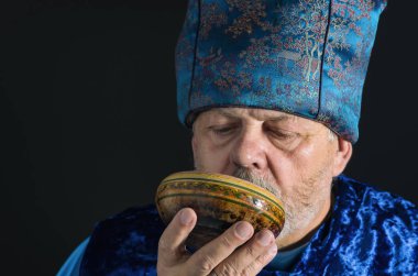 Güzel mavi oryantal giysili piola çay içme sakallı üst düzey adam portresi 