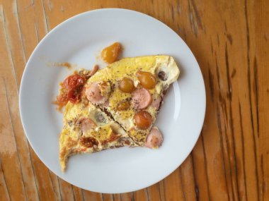 Kiraz domates ve sosis parçaları ile pişirilmiş omlet ile plaka üzerinde Üstten Görünüm