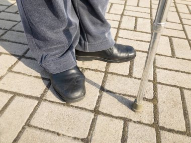 Bir kaldırım üzerinde baston duran adamla 