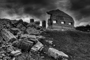 Kerpiç karanlık gökyüzüne karşı bir tepede harabeleri.