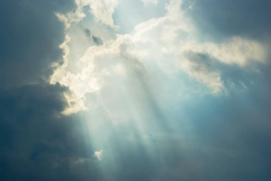 Fırtına öncesi gökyüzünde güneş ışığı ışınları.