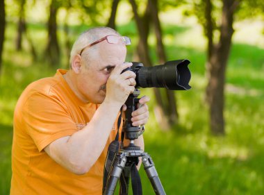 Hevesli olgun fotoğrafçı açık havada profesyonel fotoğraf çekmek.