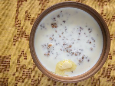 Damalı masa örtüsü üzerinde duran süt pişmiş karabuğday ile bir kase üzerinde üst görünümü 