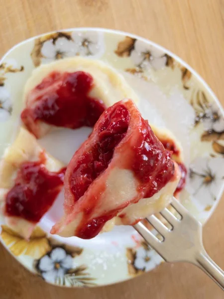 Ukrainische varenik auf einer Gabel mit Kirschbeeren gefüllt und mit Himbeerpüree gewürzt — Stockfoto