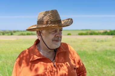 Yeşil tarımsal alan ve ileriye bakarak sakallı Kafkas kıdemli çiftçi portresi