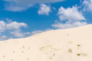Mavi bulutlu gökyüzüne karşı Dnipro nehir kumu tepesi ile yaz manzarası