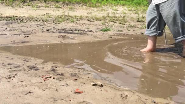 夏の季節に地球の道路上のプールを裸足で歩く杖を持つ太りすぎの高齢者 — ストック動画